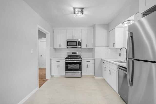 139 Jean Ave, Hempstead, NY 11550 - kitchen with stainless steel appliances, white cabinets, decorative backsplash, and light countertops