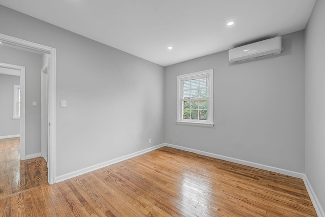 139 Jean Ave, Hempstead, NY 11550 - spare room with an AC wall unit, light wood-style flooring, and recessed lighting