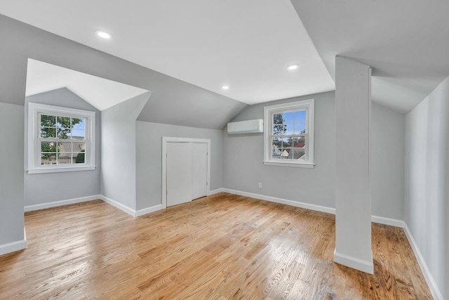 139 Jean Ave, Hempstead, NY 11550 - additional living space with an AC wall unit, vaulted ceiling, plenty of natural light, and wood finished floors
