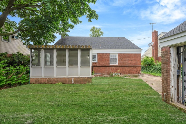 139 Jean Ave, Hempstead, NY 11550 - rear view of property featuring a sunroom, a lawn, brick siding, and a shingled roof