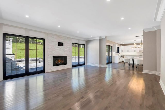 589 Old Bridge Rd, Northport, NY 11768 - unfurnished living room with dark wood-style floors, a fireplace, recessed lighting, a chandelier, and ornamental molding