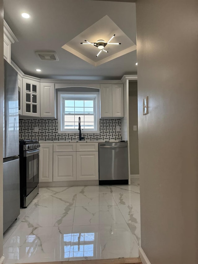 4642 Murdock Ave, Bronx, NY 10466 - kitchen featuring appliances with stainless steel finishes, decorative backsplash, white cabinetry, glass insert cabinets, and recessed lighting