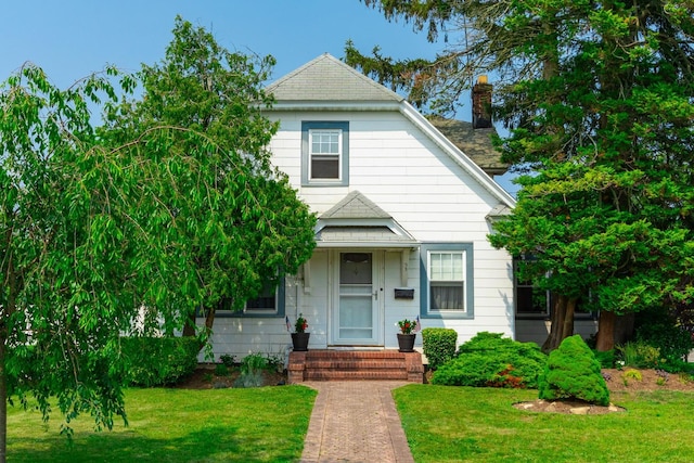 53 Community Rd, Bay Shore, NY 11706 - view of front facade featuring a front yard and a chimney