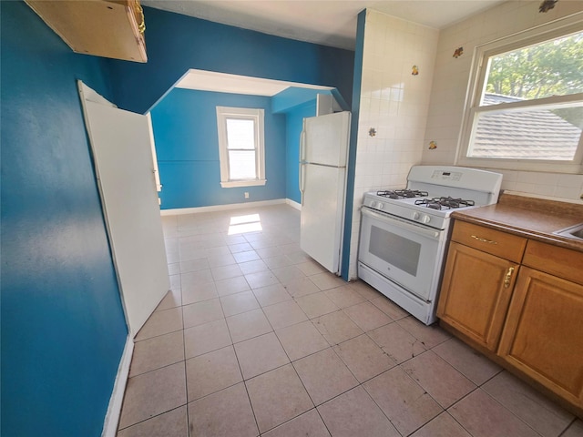 33 Thorne Ave, Hempstead, NY 11550 - kitchen with white appliances, light tile patterned flooring, and brown cabinets