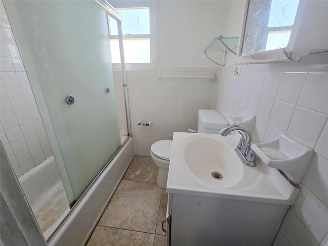 33 Thorne Ave, Hempstead, NY 11550 - bathroom with plenty of natural light, tile walls, shower / bath combination with glass door, vanity, and tile patterned flooring