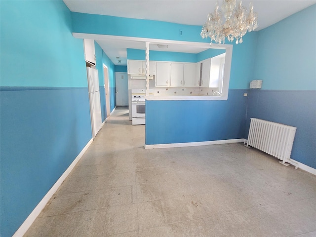 33 Thorne Ave, Hempstead, NY 11550 - kitchen with radiator heating unit, white appliances, under cabinet range hood, white cabinetry, and a chandelier