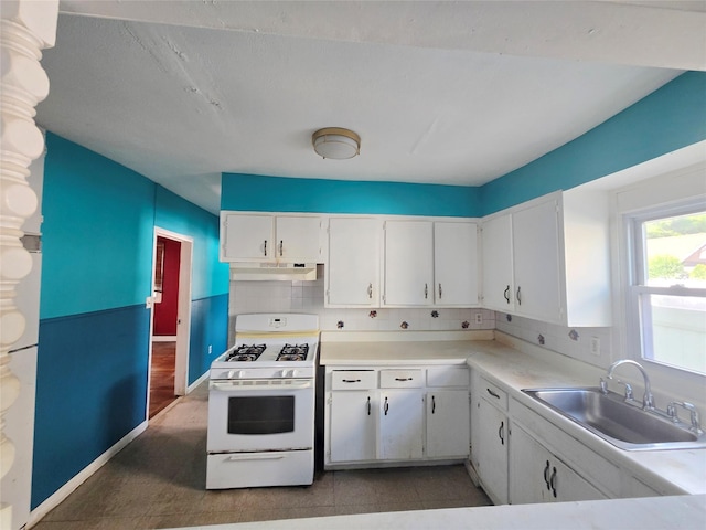 33 Thorne Ave, Hempstead, NY 11550 - kitchen featuring white gas range, under cabinet range hood, white cabinets, light countertops, and tasteful backsplash