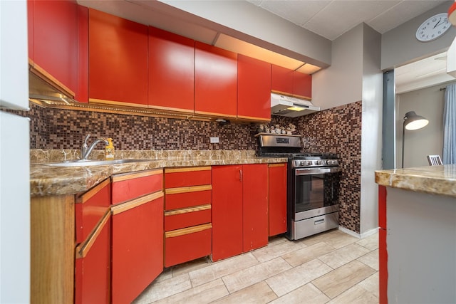 92-29 Queens Blvd Unit 14B, Rego Park, NY 11374 - kitchen with red cabinets, gas stove, under cabinet range hood, and tasteful backsplash