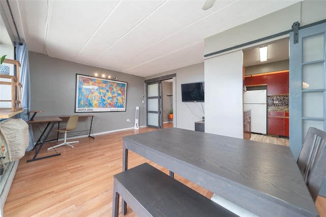 92-29 Queens Blvd Unit 14B, Rego Park, NY 11374 - dining area featuring a barn door and light wood finished floors