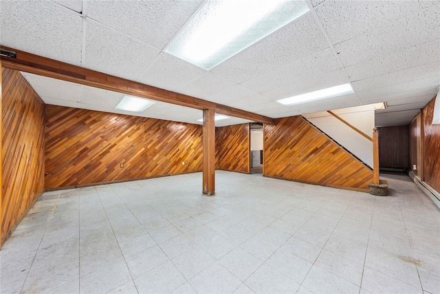 48-67 187th St, Fresh Meadows, NY 11365 - finished basement featuring wooden walls, stairs, a drop ceiling, and a baseboard radiator