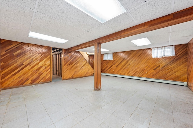 48-67 187th St, Fresh Meadows, NY 11365 - basement featuring wooden walls, a baseboard heating unit, a drop ceiling, and tile patterned floors