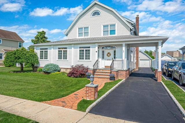 33 S Bay Ave, Amityville, NY 11701 - view of front of property featuring an outdoor structure, a front lawn, a detached garage, a gambrel roof, and a chimney