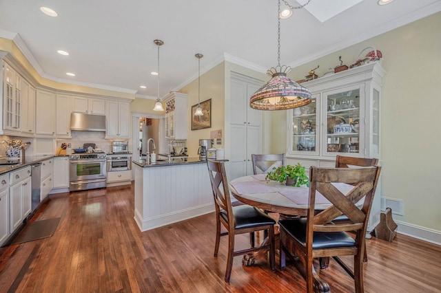 33 S Bay Ave, Amityville, NY 11701 - dining area featuring dark wood-type flooring, crown molding, a skylight, and recessed lighting