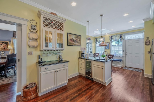 33 S Bay Ave, Amityville, NY 11701 - kitchen with a peninsula, beverage cooler, dark wood finished floors, dark countertops, and crown molding