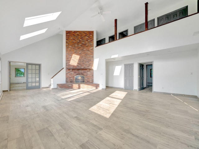 285 Hill Rd, Goshen, NY 10940 - unfurnished living room with high vaulted ceiling, a fireplace, a skylight, ceiling fan, and wood finished floors