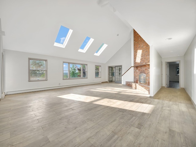 285 Hill Rd, Goshen, NY 10940 - unfurnished living room featuring a skylight, a brick fireplace, high vaulted ceiling, light wood-style floors, and baseboard heating