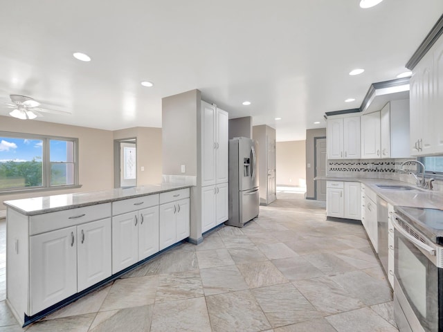 285 Hill Rd, Goshen, NY 10940 - kitchen with appliances with stainless steel finishes, a ceiling fan, a peninsula, light stone countertops, and white cabinets