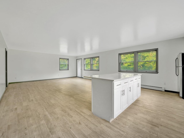 285 Hill Rd, Goshen, NY 10940 - kitchen featuring a baseboard radiator, light countertops, a kitchen island, white cabinets, and light wood finished floors