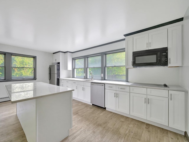 285 Hill Rd, Goshen, NY 10940 - kitchen featuring black appliances, light wood-style flooring, white cabinets, a kitchen island, and light stone counters