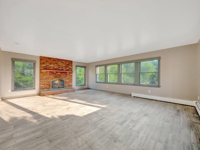 285 Hill Rd, Goshen, NY 10940 - unfurnished living room with healthy amount of natural light, a fireplace, wood finished floors, and baseboard heating