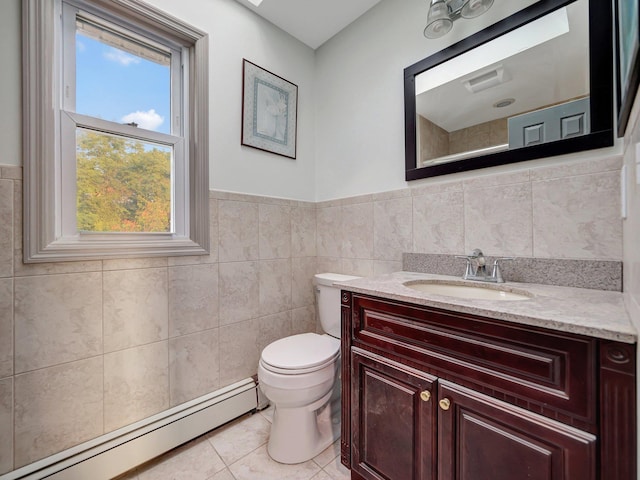 285 Hill Rd, Goshen, NY 10940 - bathroom with a baseboard heating unit, tile walls, vanity, tile patterned floors, and a wainscoted wall