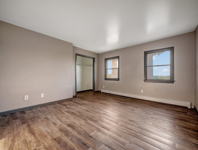 285 Hill Rd, Goshen, NY 10940 - unfurnished bedroom featuring baseboard heating, wood finished floors, and a closet