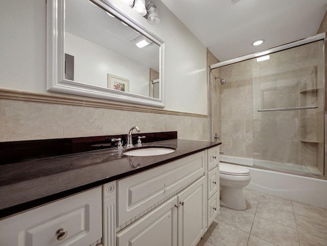 285 Hill Rd, Goshen, NY 10940 - full bathroom featuring vanity, bath / shower combo with glass door, tile patterned floors, tile walls, and a wainscoted wall