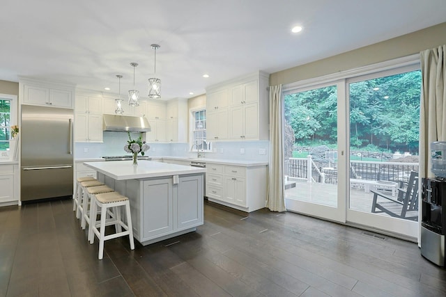 29 Brian Ct, Carmel, NY 10512 - kitchen with under cabinet range hood, built in fridge, white cabinets, a center island, and light countertops