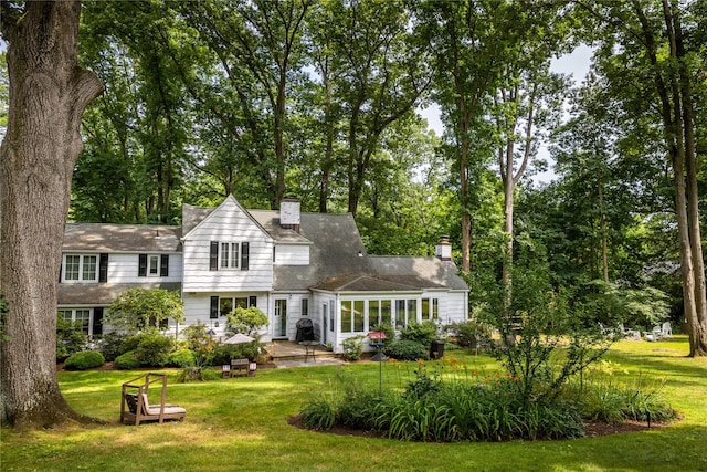 15 Glen Pk Rd, Purchase, NY 10577 - back of property featuring a yard, a sunroom, a chimney, and a patio