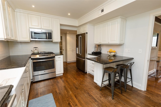 15 Glen Pk Rd, Purchase, NY 10577 - kitchen with appliances with stainless steel finishes, white cabinets, dark wood-style floors, decorative backsplash, and crown molding
