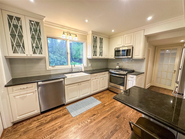 15 Glen Pk Rd, Purchase, NY 10577 - kitchen featuring appliances with stainless steel finishes, dark countertops, dark wood-style floors, ornamental molding, and white cabinetry