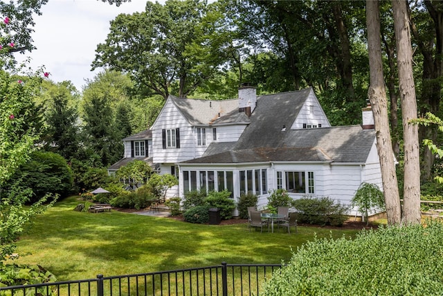 15 Glen Pk Rd, Purchase, NY 10577 - back of house with a chimney, a shingled roof, and view of wooded area