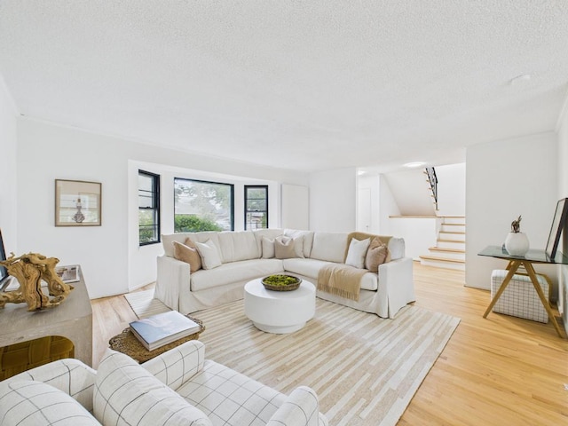811 Bellmore Ave, East Meadow, NY 11554 - living room featuring stairs, a textured ceiling, and light wood-style floors