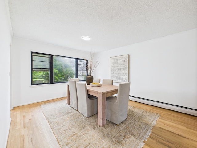 811 Bellmore Ave, East Meadow, NY 11554 - dining room with wood finished floors, a textured ceiling, and baseboard heating