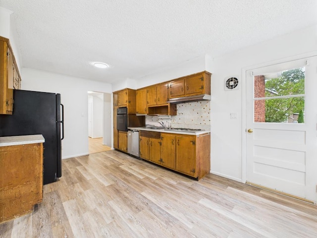 811 Bellmore Ave, East Meadow, NY 11554 - kitchen featuring black appliances, a textured ceiling, light wood-style flooring, brown cabinetry, and light countertops