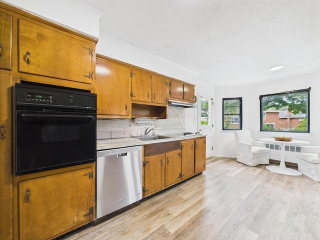 811 Bellmore Ave, East Meadow, NY 11554 - kitchen with oven, dishwasher, a textured ceiling, brown cabinets, and light wood-style floors