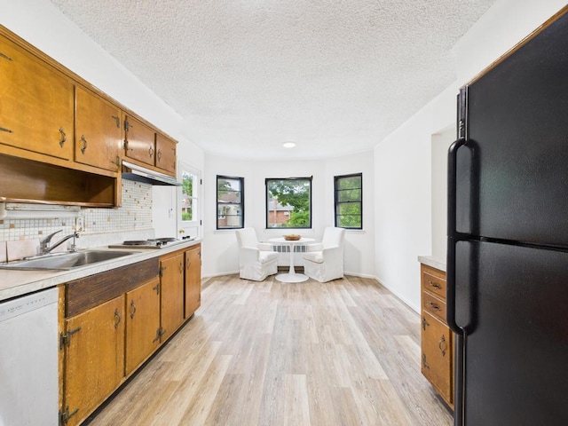 811 Bellmore Ave, East Meadow, NY 11554 - kitchen with freestanding refrigerator, white dishwasher, light wood-style flooring, a textured ceiling, and brown cabinets