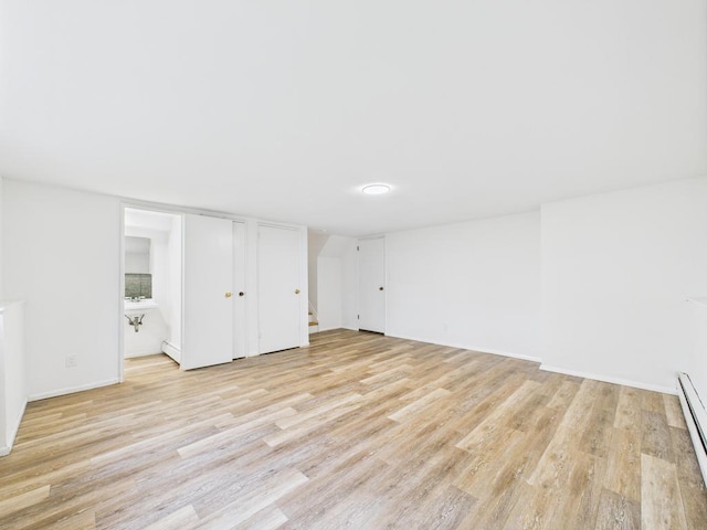 811 Bellmore Ave, East Meadow, NY 11554 - finished below grade area with light wood-type flooring, stairway, and a baseboard radiator