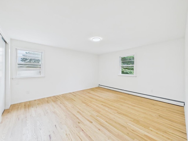 811 Bellmore Ave, East Meadow, NY 11554 - spare room with a baseboard radiator and wood finished floors