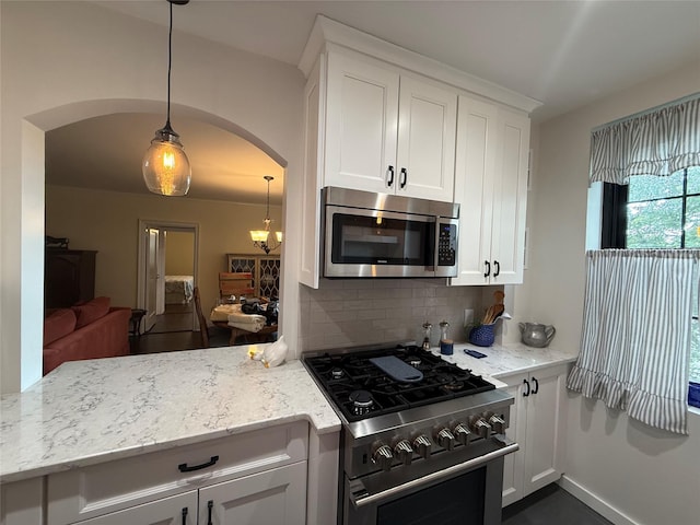 1273 N Ave Unit 4F-5, New Rochelle, NY 10804 - kitchen featuring appliances with stainless steel finishes, arched walkways, backsplash, a peninsula, and white cabinets