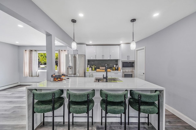 73 S Evergreen Dr, Selden, NY 11784 - kitchen featuring appliances with stainless steel finishes, white cabinets, recessed lighting, tasteful backsplash, and hanging light fixtures