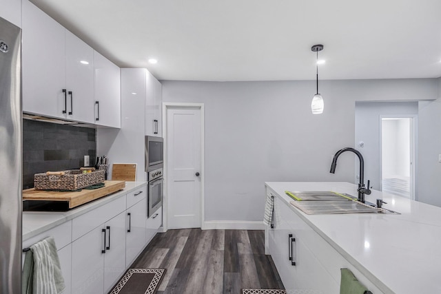 73 S Evergreen Dr, Selden, NY 11784 - kitchen with appliances with stainless steel finishes, light countertops, white cabinets, decorative backsplash, and dark wood-style flooring