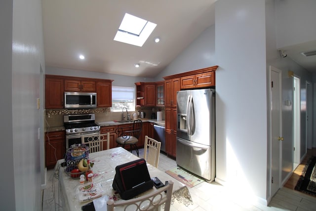 242 W Centennial Ave, Roosevelt, NY 11575 - kitchen featuring appliances with stainless steel finishes, a skylight, vaulted ceiling, decorative backsplash, and recessed lighting