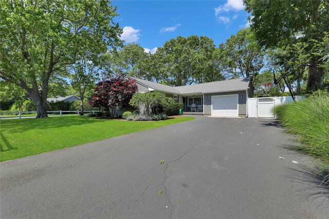 75 Lynncliff Rd, Hampton Bays, NY 11946 - view of front of home with an attached garage, asphalt driveway, and a gate