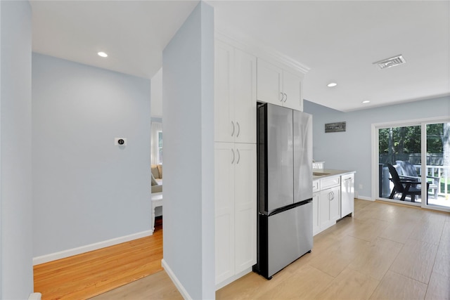 75 Lynncliff Rd, Hampton Bays, NY 11946 - kitchen featuring freestanding refrigerator, light wood-style floors, dishwasher, white cabinets, and light countertops