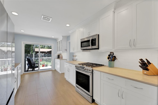 75 Lynncliff Rd, Hampton Bays, NY 11946 - kitchen featuring appliances with stainless steel finishes, white cabinets, decorative backsplash, light countertops, and recessed lighting