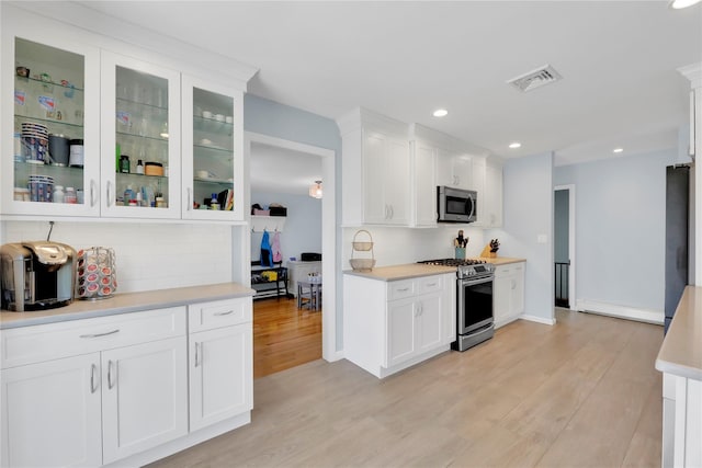 75 Lynncliff Rd, Hampton Bays, NY 11946 - kitchen with stainless steel appliances, light wood finished floors, white cabinetry, light countertops, and recessed lighting