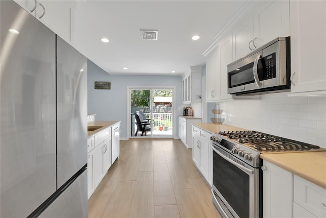 75 Lynncliff Rd, Hampton Bays, NY 11946 - kitchen featuring appliances with stainless steel finishes, light countertops, white cabinets, and recessed lighting