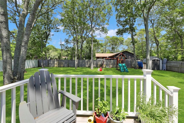 75 Lynncliff Rd, Hampton Bays, NY 11946 - deck with a playground, a shed, a fenced backyard, and view of scattered trees