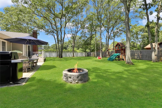 75 Lynncliff Rd, Hampton Bays, NY 11946 - fenced backyard featuring a fire pit and a playground